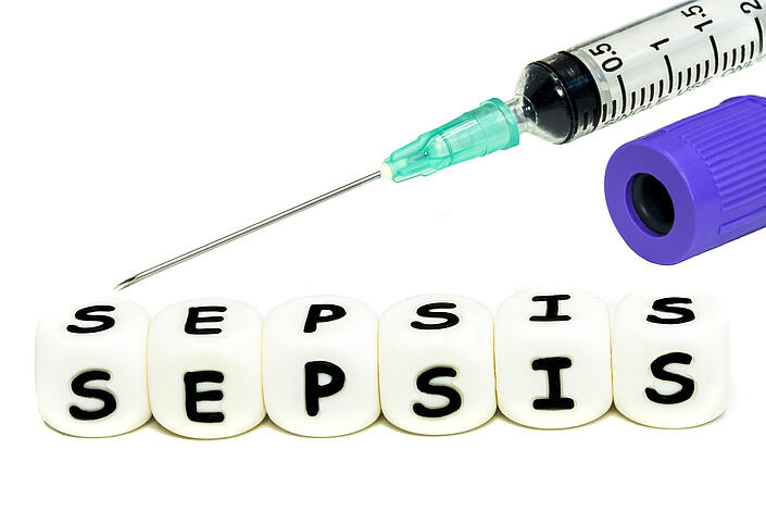 Würfel mit Schrifftzug "Sepsis" und Spritze