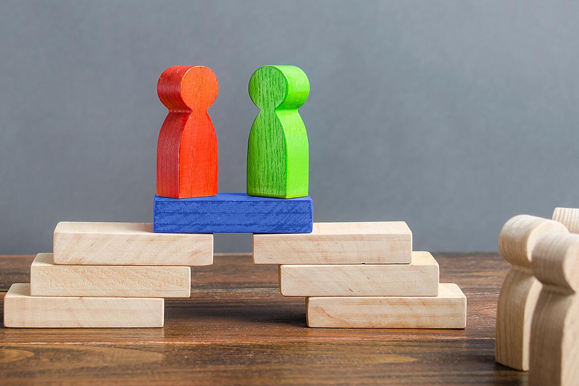 Symbolbild Holzfiguren rot und grün