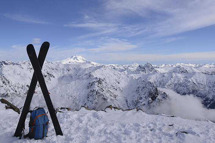 Skier stecken im Schnee auf einem Berggipfel 