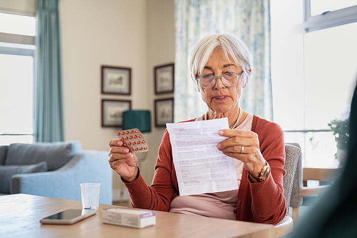 Ältere Damen liest den Beipackzettel ihres Medikamentes