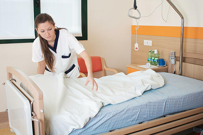 Krankenpflegerin bezieht ein Krankenhausbett